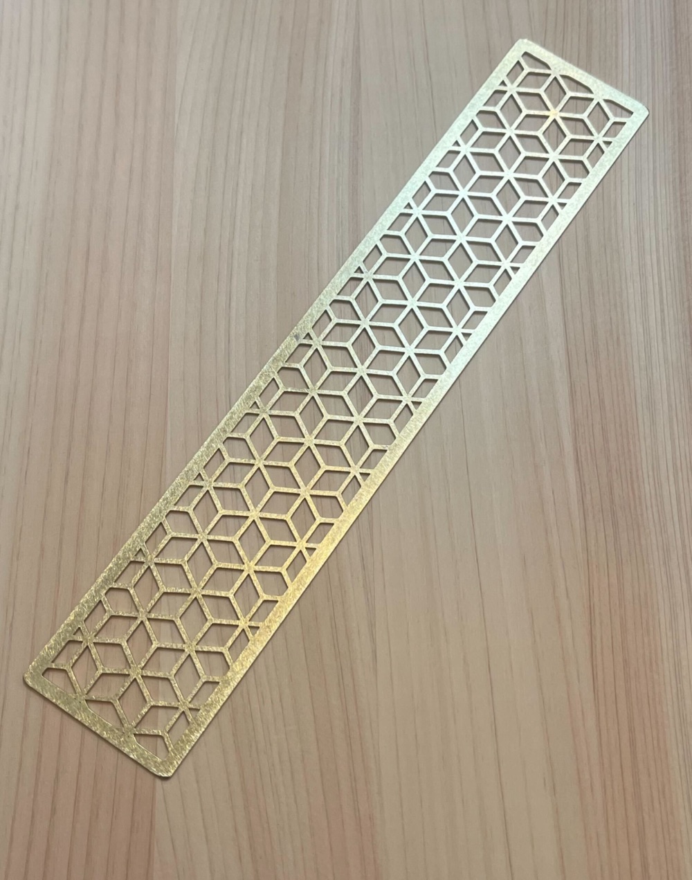 Brass bookmark with cube pattern.