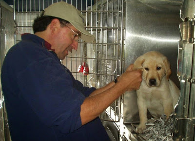 Mick Aguilera with a yellow Lab puppy.