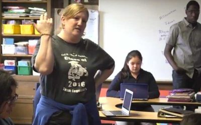 Photo of teacher explaining concept to a group of students