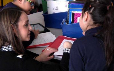 Photo of teacher working with two students