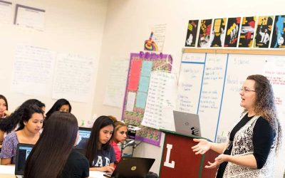 Photo of teacher speaking to a group of students in classroom