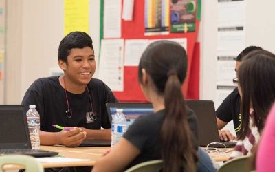 Photo of group of students seated at table in discussion
