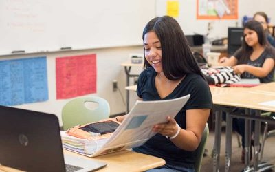 Photo of student viewing her binder with laptop in front