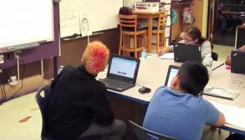 Photo of seated students looking at projector in front of classroom