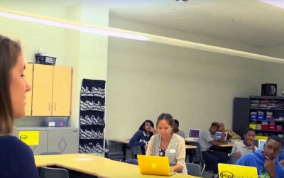Photo of teacher speaking to large class of students
