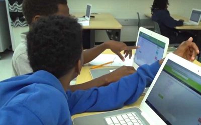 Photo of two student partners working together on laptops