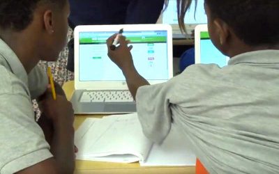 Photo of students working together on laptop computers