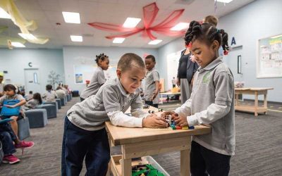 Photo of two students working collaboratively on Legos at table