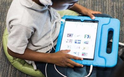 Photo closeup of device screen showing student playlist with student in background