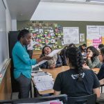 Photo of teacher working with small group of students around a table