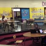 Photo of open classroom with students seated in different areas
