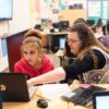Photo of teacher and student working together in front of lap top
