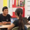 Photo of group of students seated at table in discussion