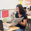 Photo of student viewing her binder with laptop in front
