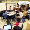 Photo of classroom with indication showing student is signing up for assessment on the whiteboard at front of class