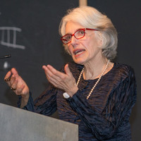 An image of Dava Sobel speaking behind a podium.