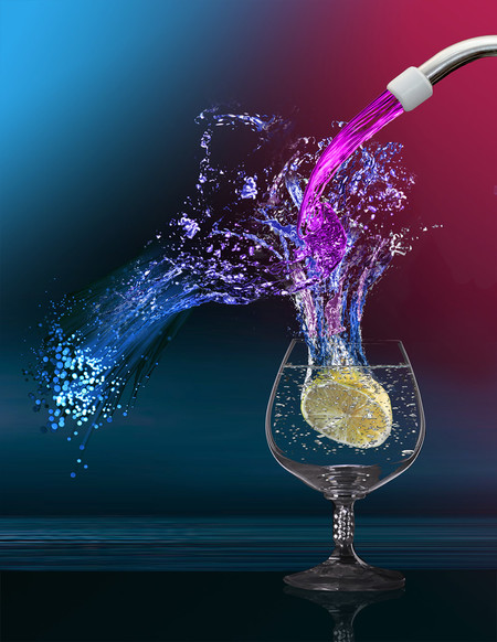 Water pouring into a glass with a lemon in it.