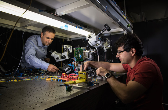 photo of Ali Hajimiri and Behrooz Abiri working with the camera sensor setup in their lab