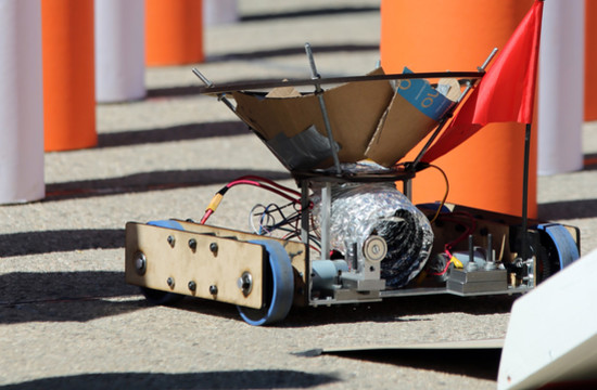A Team Fridge robot at the end of the pylon section awaits the handoff of a ball for delivery to the end of the course.