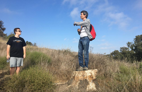 Paul Asimow, the Eleanor and John R. McMillan Professor of Geology and Geochemistry, talks to students from atop a stump during the Frosh Camp geology hike.