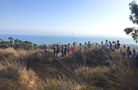Students gather atop a bluff overlooking the ocean during a geology hike that is part of Frosh Camp.