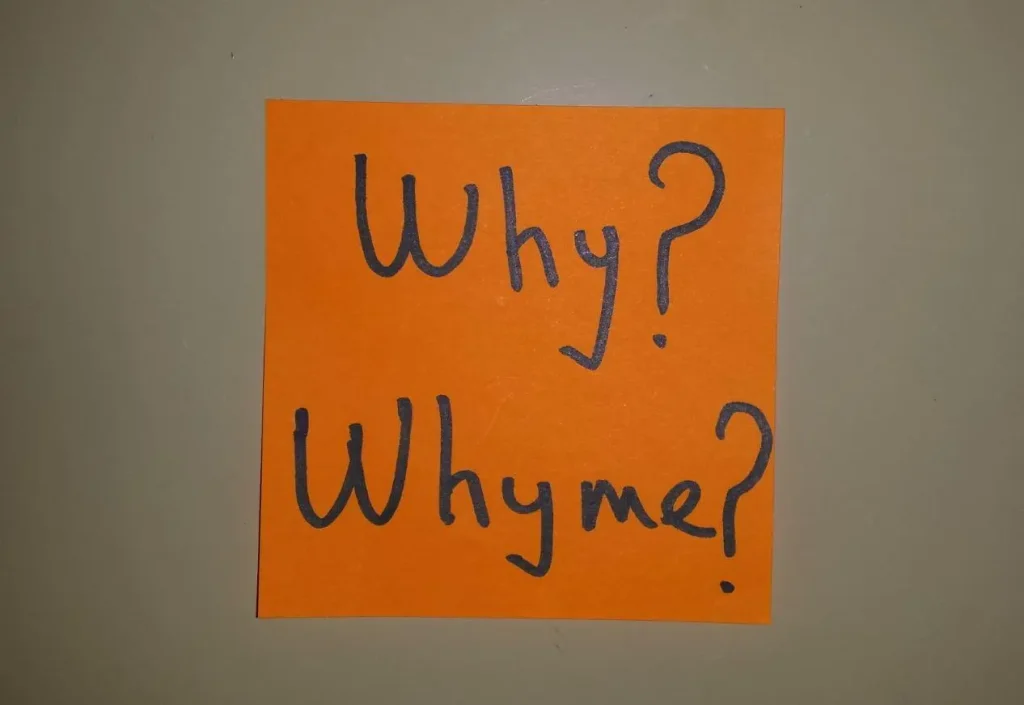 An orange note with 'Why? Why me?' written on it, questioning reasons.