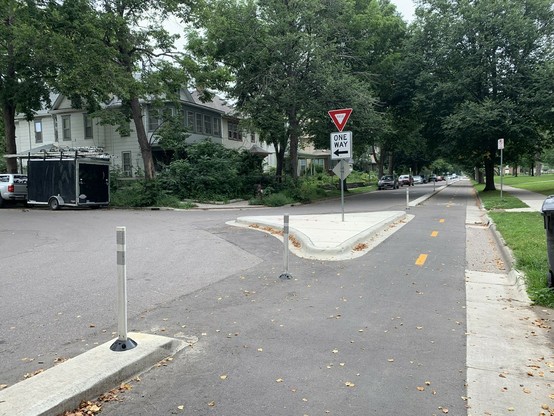 curb protected two way bike lanes and a diverter that channels car traffic onto a one-way cross street