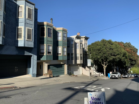 Three attached houses with no trees in front on the Page St hill