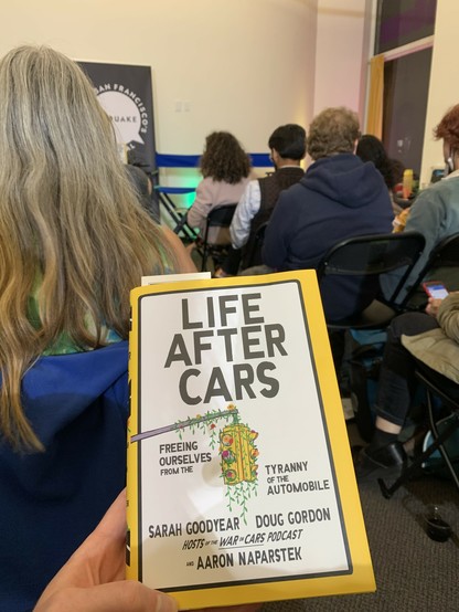 I’m holding a copy of Life After Cars: Freeing Ourselves from the Tyranny of the Automobile as I sit in the audience of a Litquake/KALW event that has yet to start.