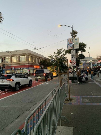 Two cars in the red, bus-only lane that goes straight, instead of the right-turn only lane that is the only lane legal for them to use. A sign says right turn only, except trucks, buses, taxis and bicycles. Up ahead you can see a line of cars that have just made the same illegal move, backed up through the intersection.