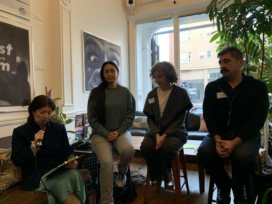 Four people seated in a storefront