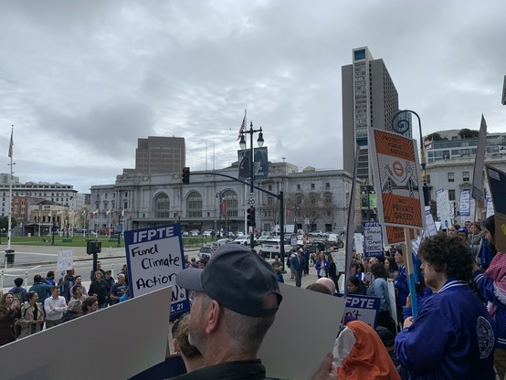 Crowd with signs on city hall steps