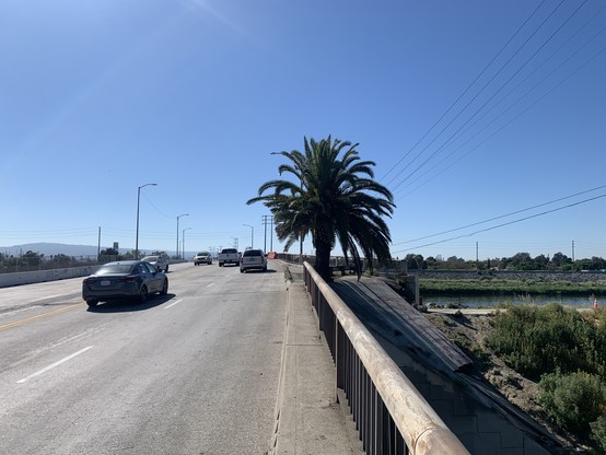 A road bridge with four lanes and no bike lane, sidewalk, or shoulder.