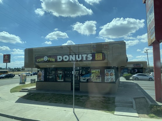 Yum Yum Donuts, open 24 hours. Small store on the corner of a big parking lot