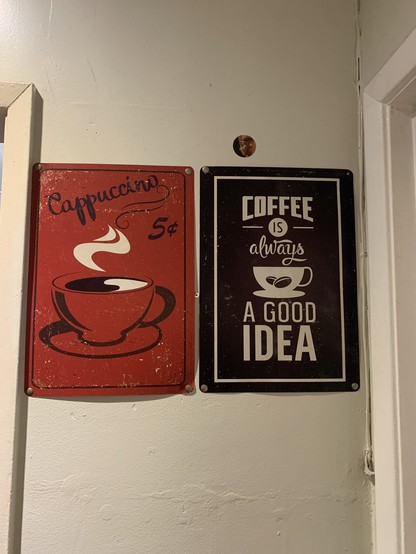 a wall with two old timey posters. One says cappuccino 5¢ with a steaming mug, drawn in black and white on a red background. The other says: coffee is always a good idea.