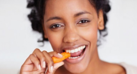 0-716446877-african-american-woman-snack-healthy-veggies-carrot
