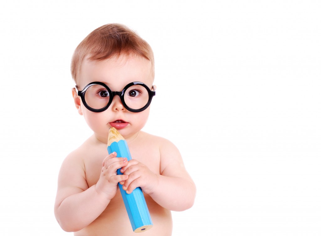 Baby boy wearing glasses and holding big pencil