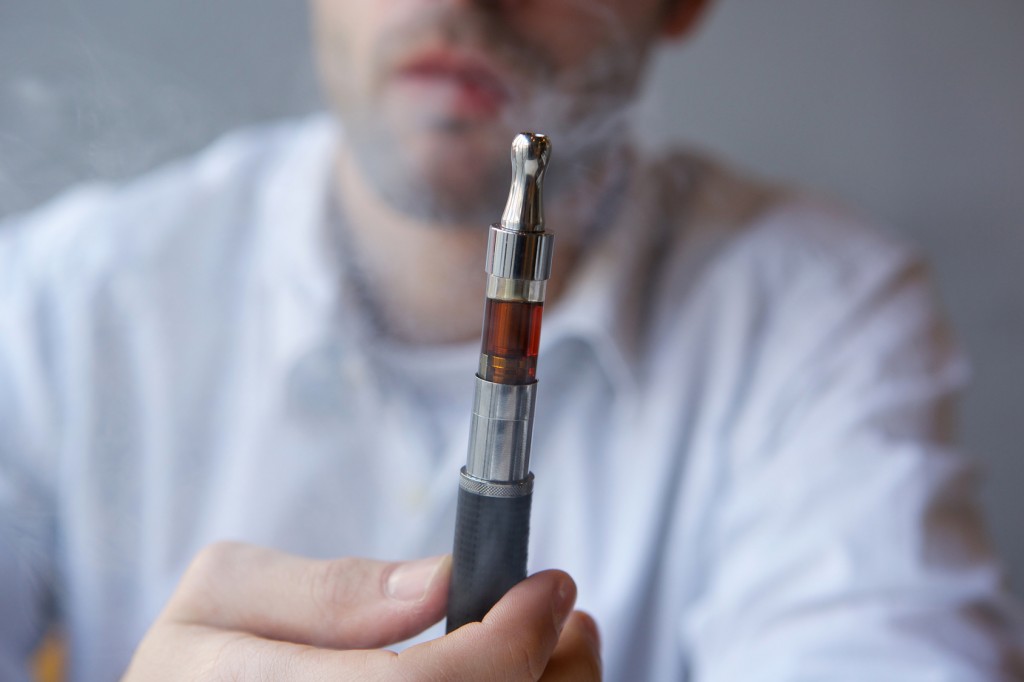 Close up part face man holding electric cigarette