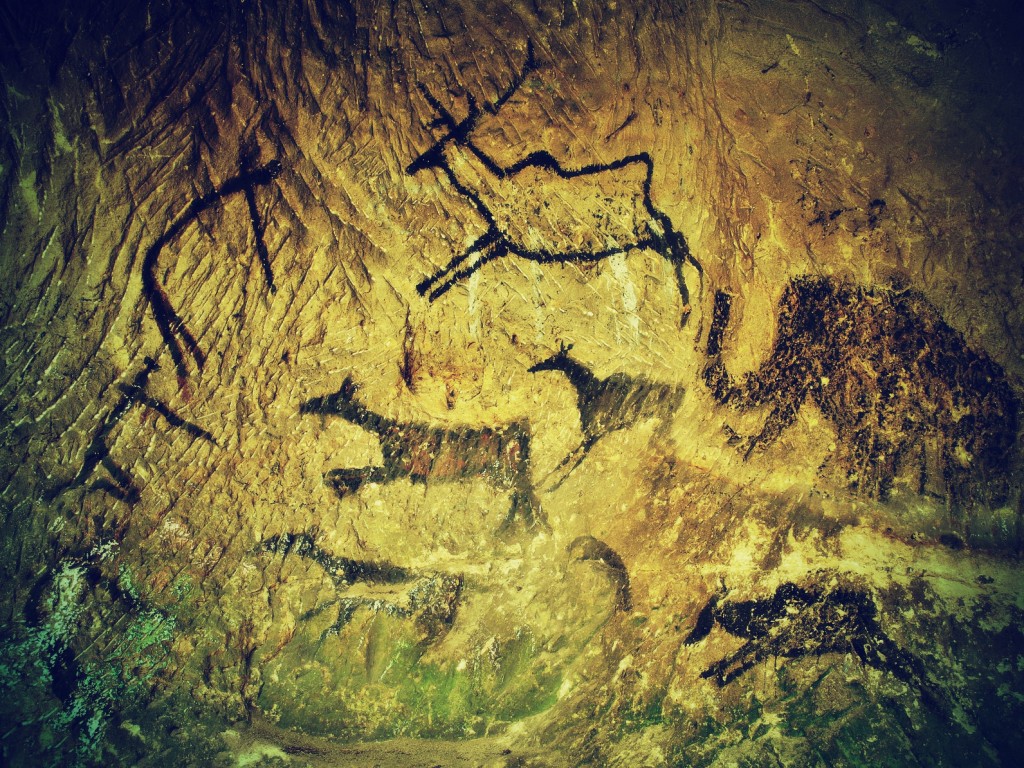 Abstract children art in sandstone cave. Black carbon paint of human hunting on sandstone wall, copy of prehistoric picture.