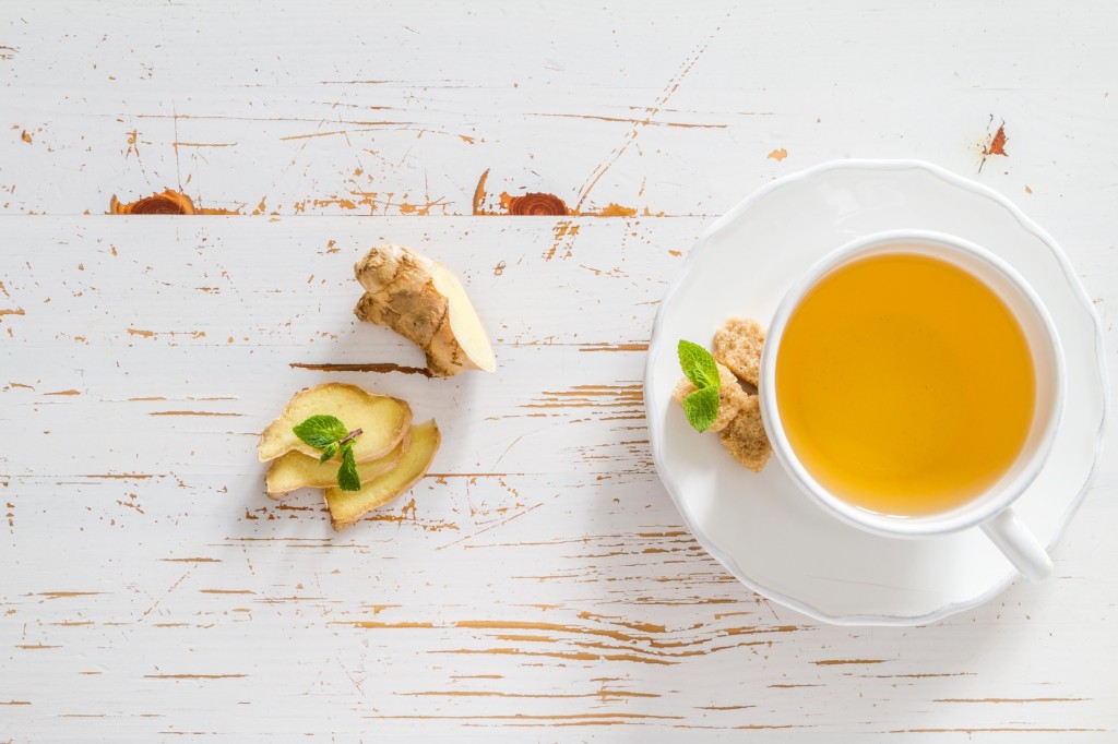Ginger tea and ingredients on white wood background, copy space