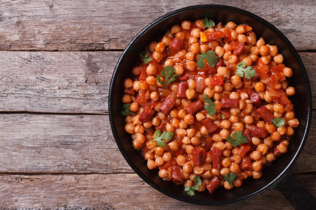 Chickpeas with chorizo in a pan top view