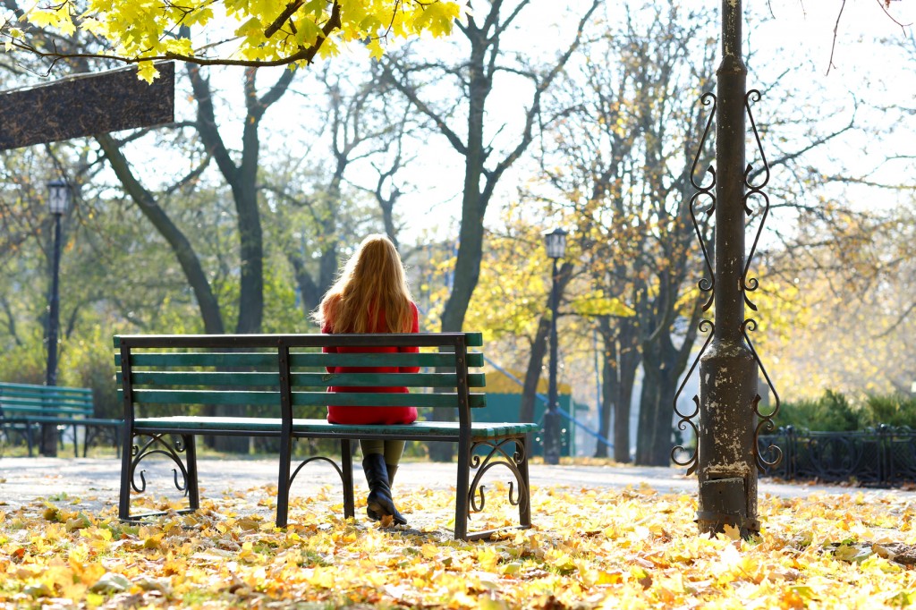 Lonely woman on bench in park