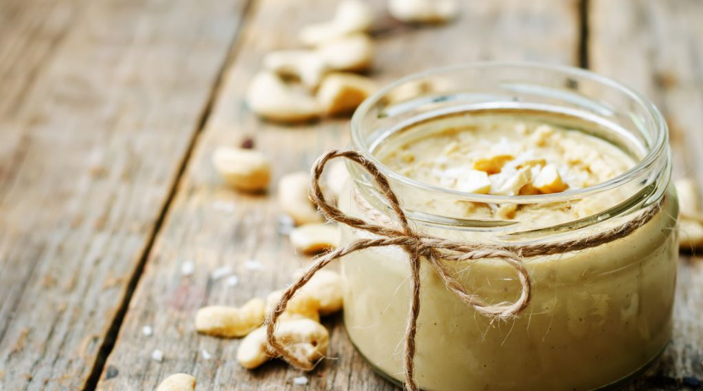 toasted cashew coconut butter on a dark wood background. toning. selective focus