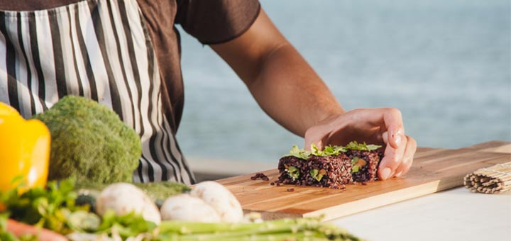man-making-sushi-beach-background