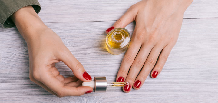 woman-applying-nail-oil