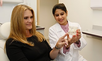 Doctor showing patient scale model of teeth