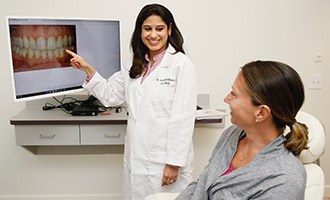 Doctor showing patient photo of teeth on a monitor
