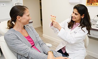 Doctor showing patient scale model of teeth