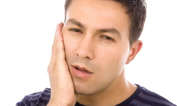 Man holding his jaw in discomfort
