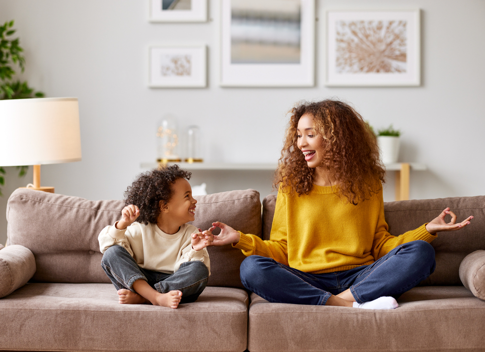 Supporting all Children to Find Calm and Focus Mother and son practicing mindfulness and social-emotional wellness techniques on a sofa.